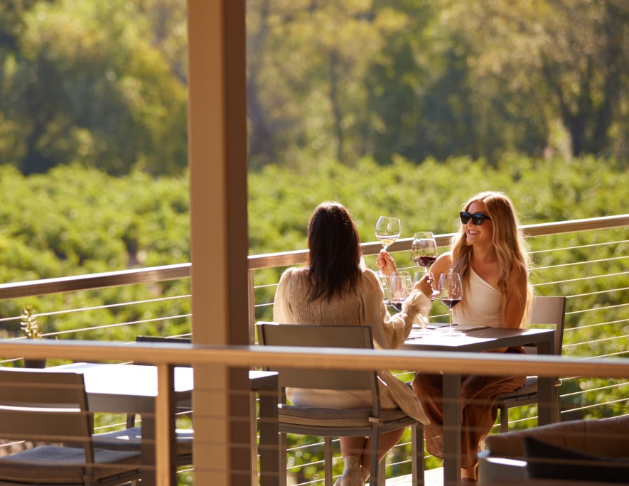 Two people enjoying wine outside.