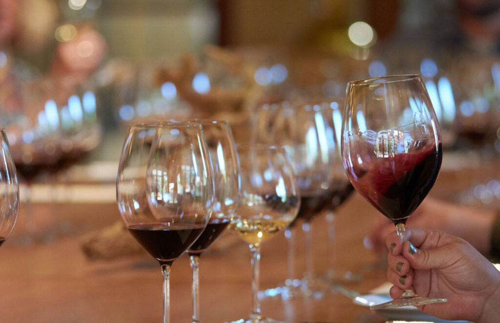 Person swirling red wine in a glass at a wine tasting