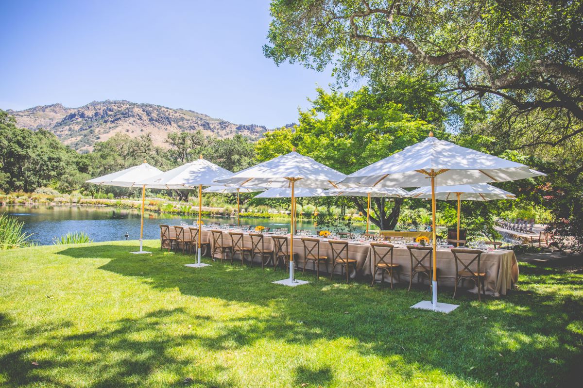 Table setting with umbrellas at FAY Lake at Stag's Leap Wine Cellars